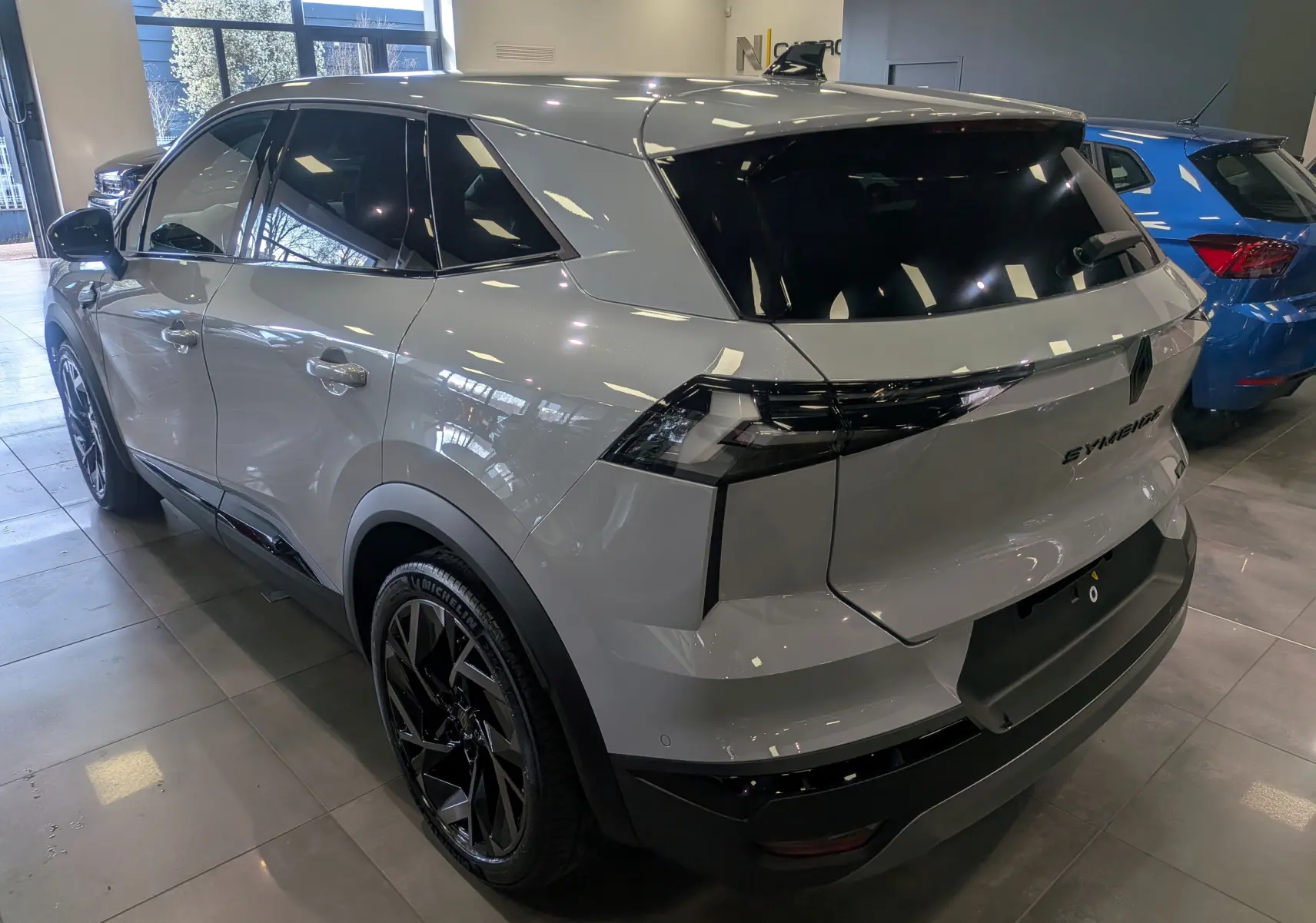 Vue 3/4 arrière droite du Renault SYMBIOZ gris Rafale avec vitres teintées et jantes noires en concession.