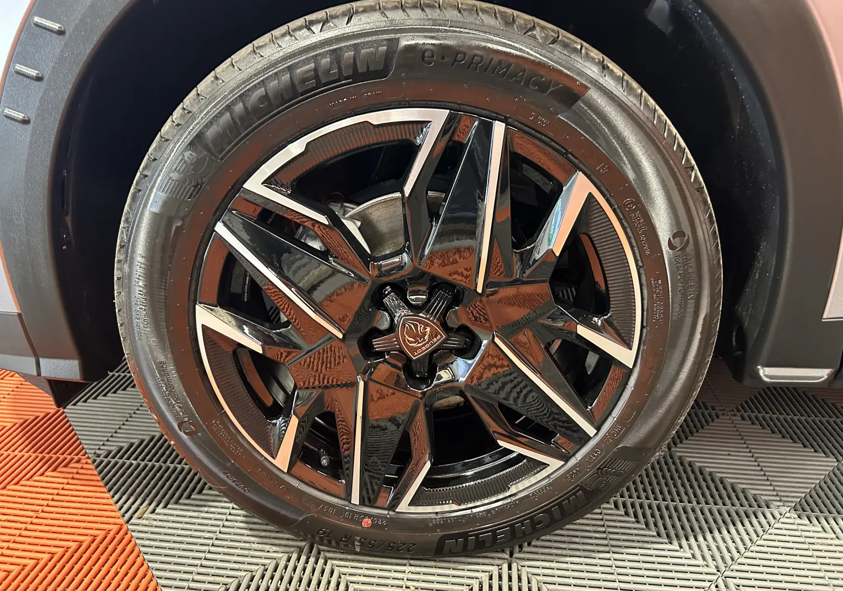 Gros plan sur la roue avant droite du Peugeot 3008 III Hybrid gris Artense avec jante alliage noire et argentée.