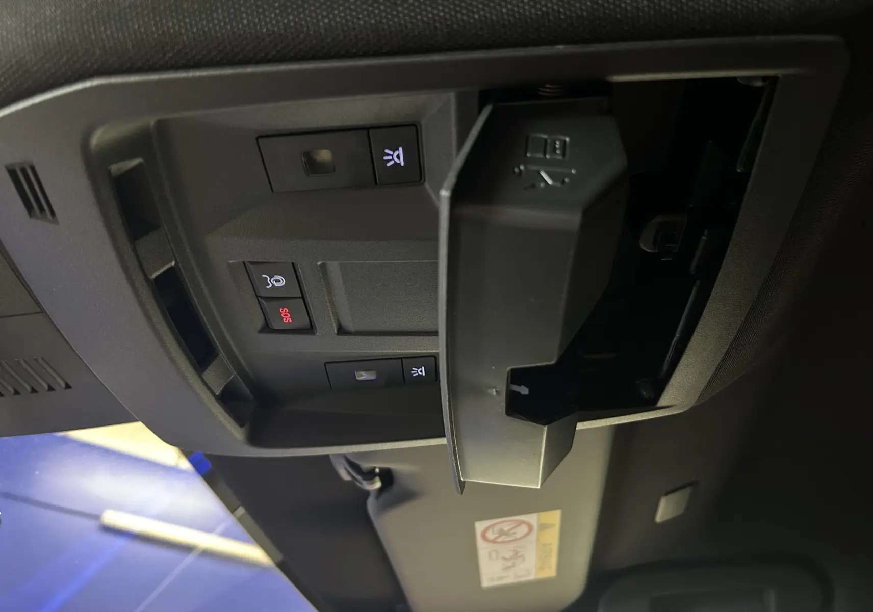 Vue intérieure du plafond avant du Peugeot 3008 gris Artense, montrant les commandes d’éclairage et un compartiment ouvert.
