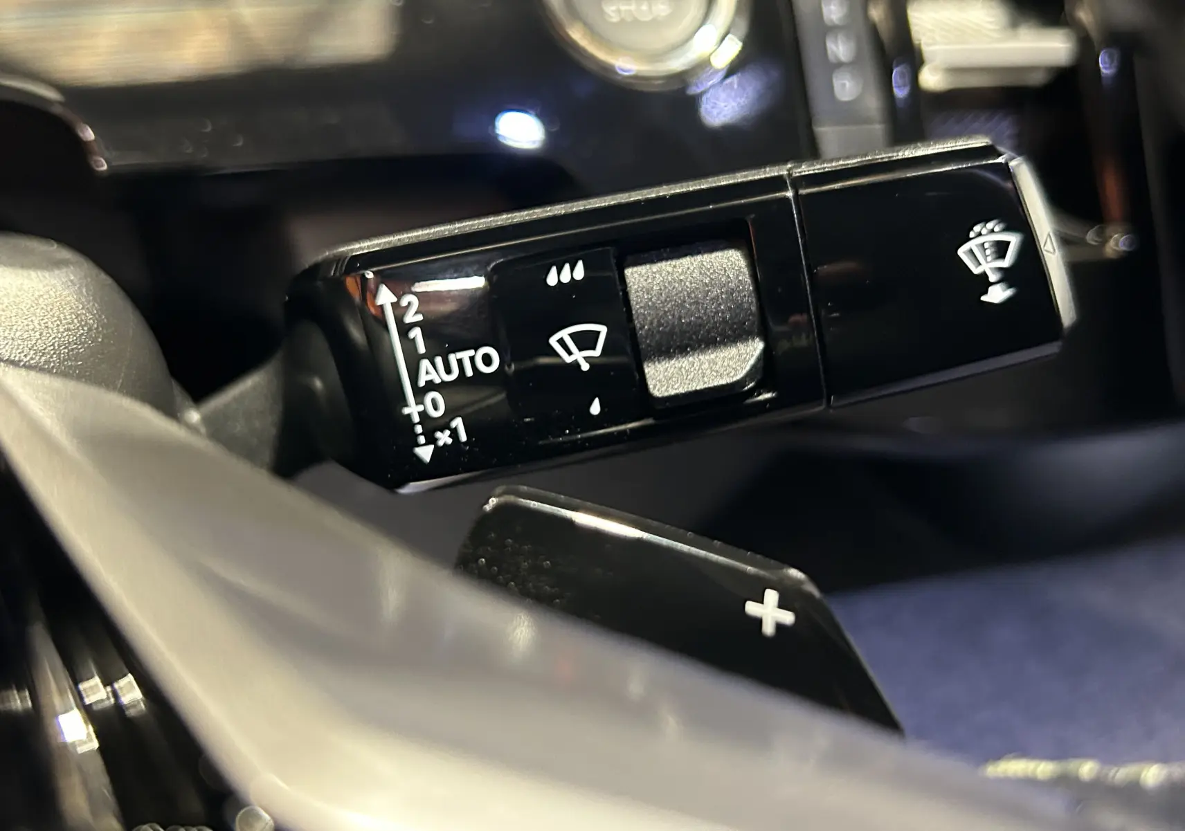 Gros plan sur la commande des essuie-glaces du Peugeot 3008 gris Artense, avec bouton start/stop en arrière-plan.