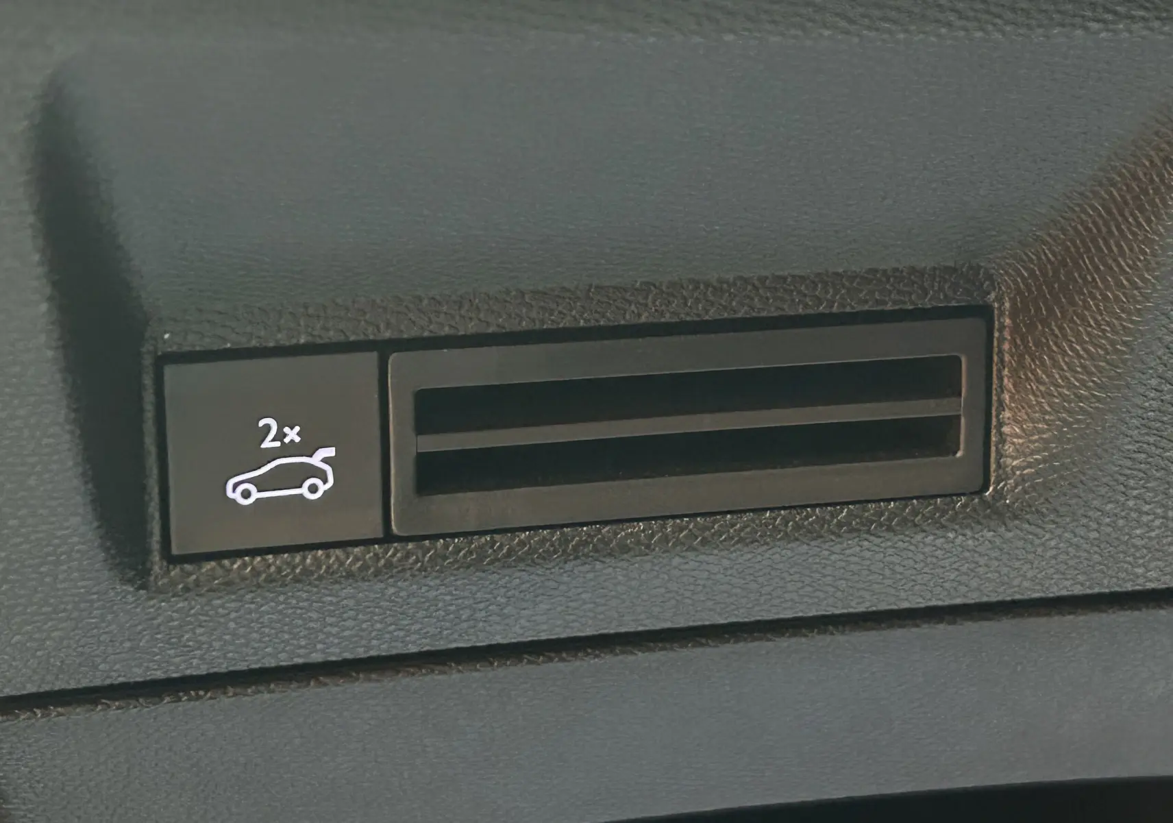 Gros plan sur le bouton d'ouverture électrique du hayon dans l'habitacle du Peugeot 3008 gris Artense.