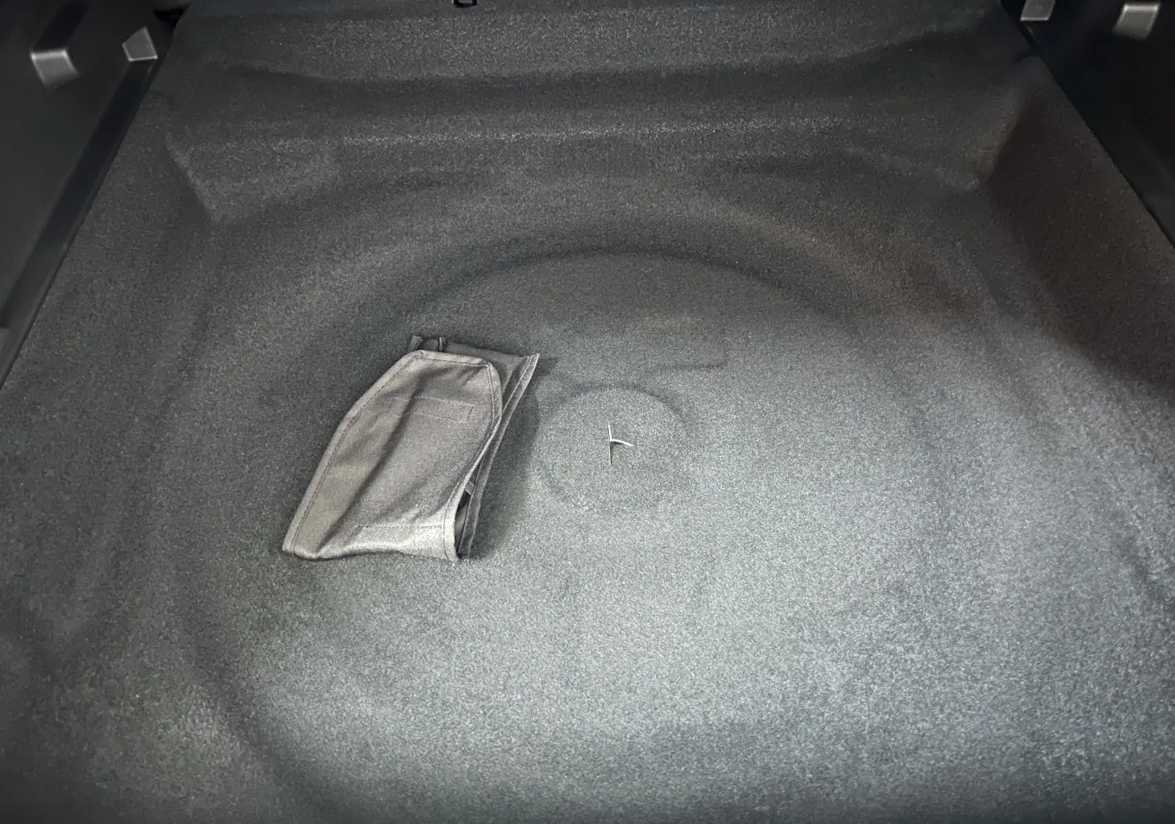 Coffre vide vu de dessus du Peugeot 3008 III Hybrid gris Artense avec tapis de sol plié au centre.