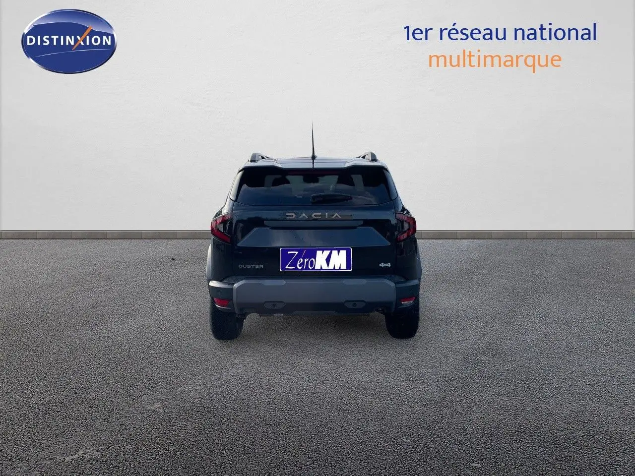 Vue arrière d'un Dacia Duster noir métal 2024 avec logo et plaque Zéro KM sur fond neutre.
