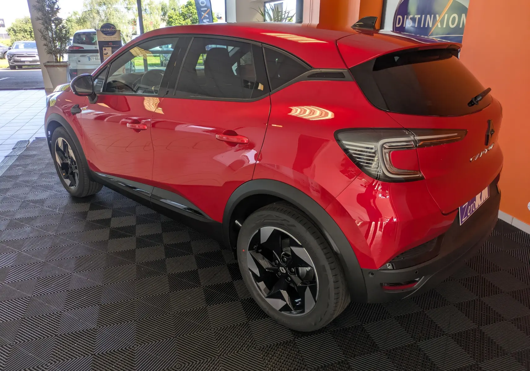 Renault Captur rouge Désir vu en 3/4 arrière droit, avec jantes 18'' biton et vitres arrière surteintées.