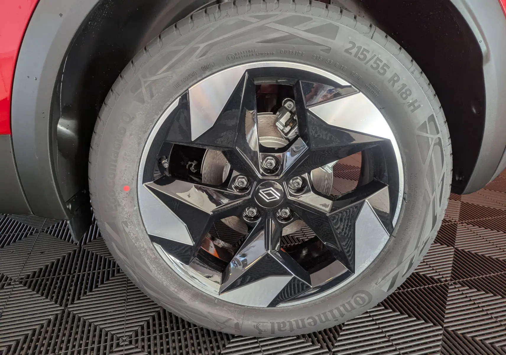Gros plan sur la jante alliage 18'' Pasadena bicolore noir et argent du Renault Captur Rouge Désir, côté gauche.