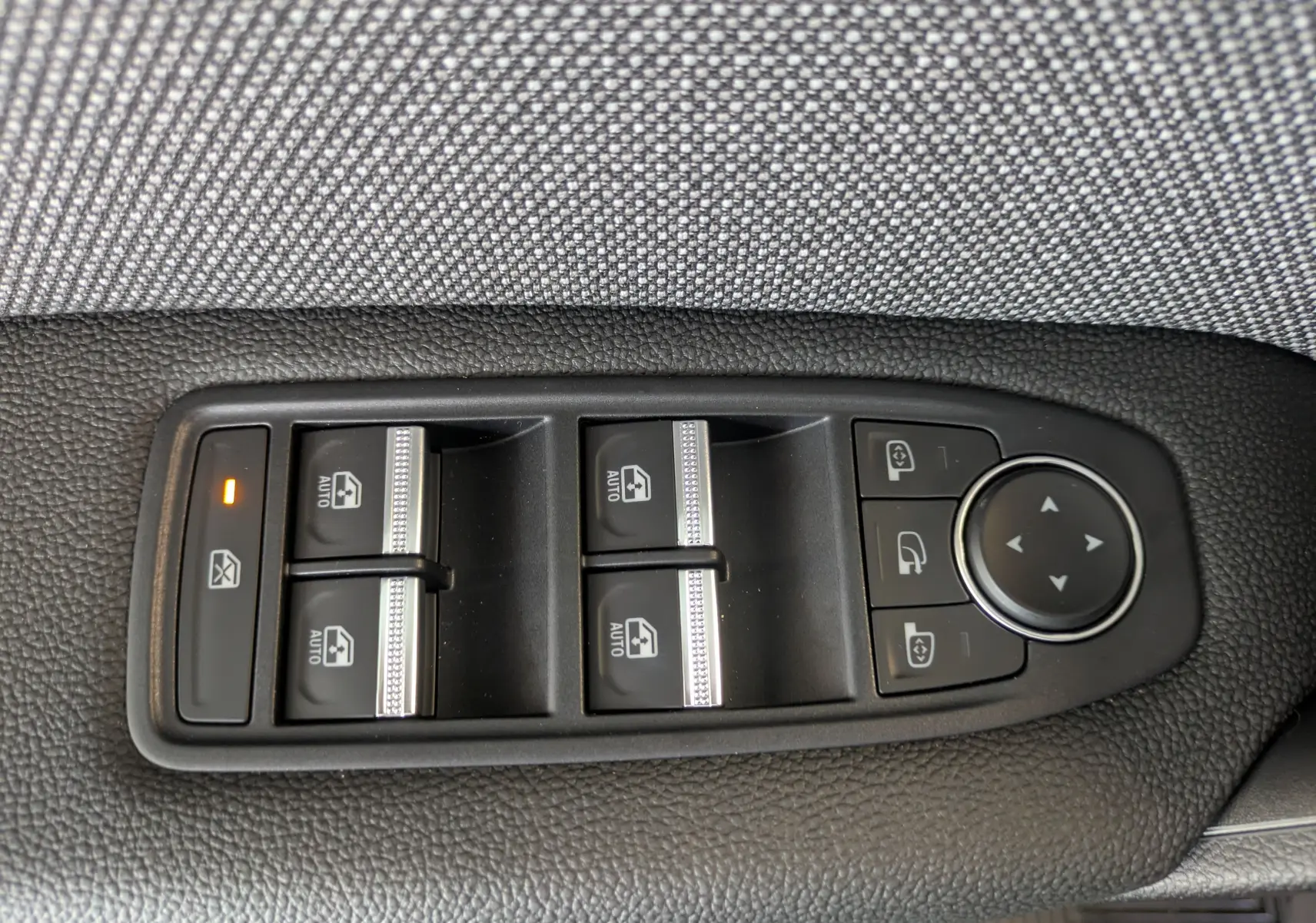 Panneau de commandes des vitres électriques et rétroviseurs côté gauche intérieur d’un Renault Captur rouge Désir 2025.