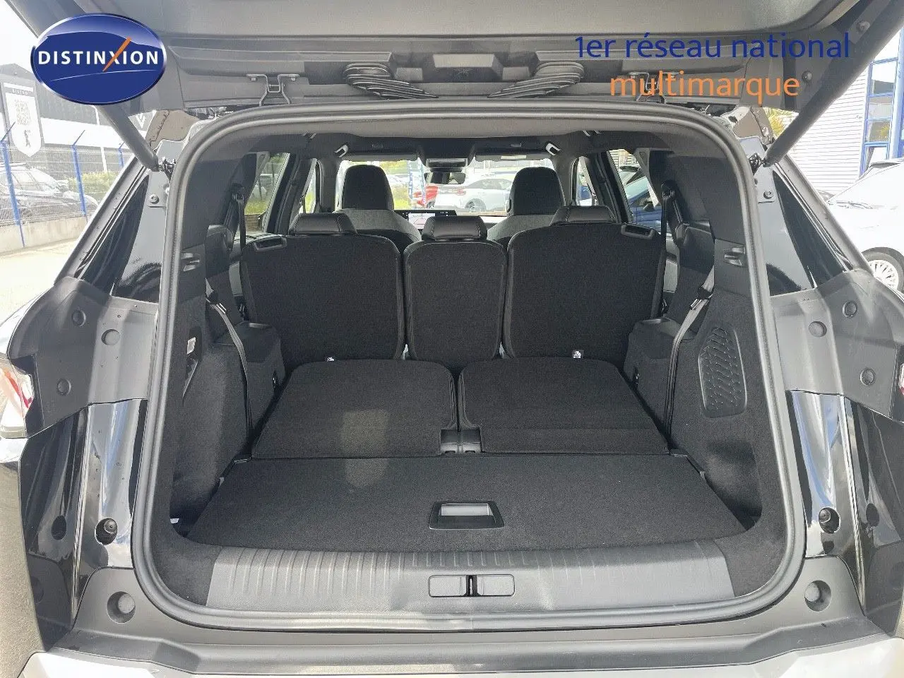 Coffre ouvert du Peugeot 5008 noir perle métal, vue arrière montrant les sièges arrière rabattus et l'espace de chargement.