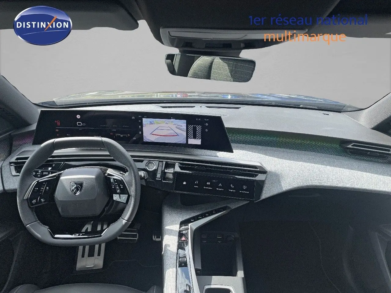 Vue intérieure du tableau de bord et volant du Peugeot 5008 Hybrid GT 2025 en noir perle métal, avec écran central et caméra de recul affichée.