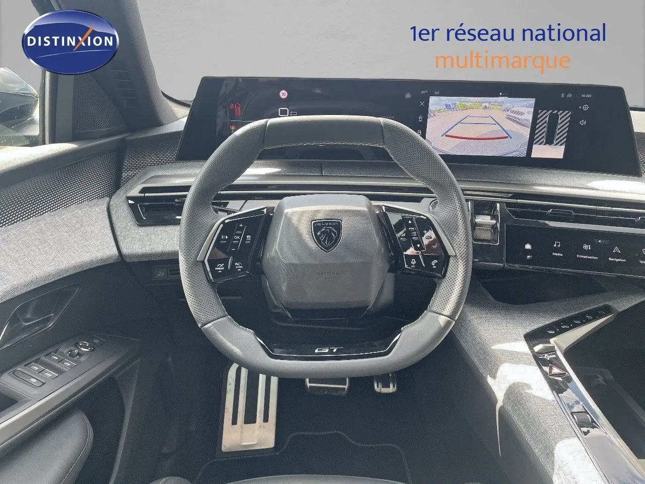 Vue frontale du poste de conduite du Peugeot 5008 Hybrid GT 2025, volant compact et écran numérique avec caméra de recul.