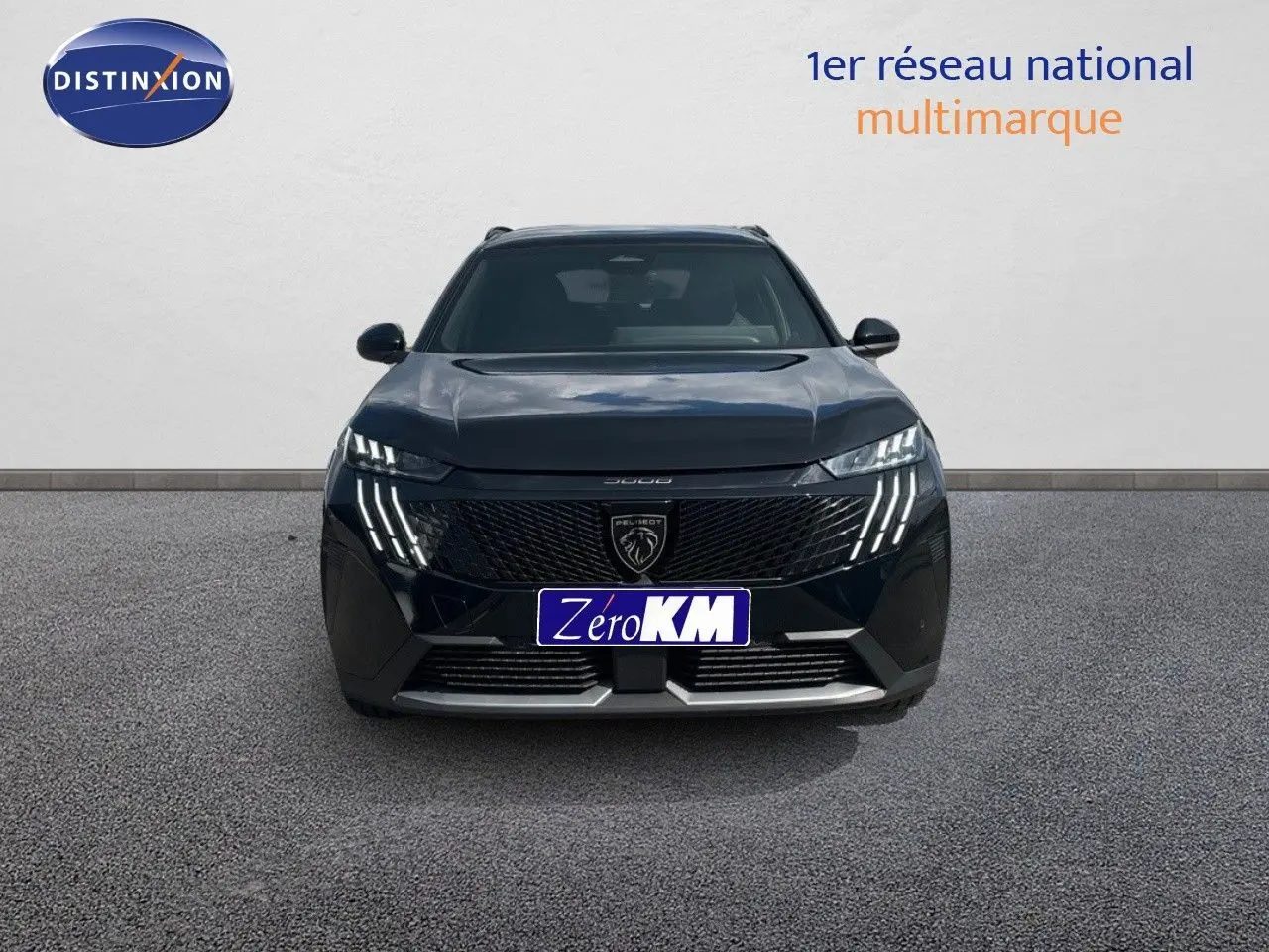 Vue de face du Peugeot 5008 HYBRID 136CH GT noir perle métal avec ses phares LED distinctifs allumés.