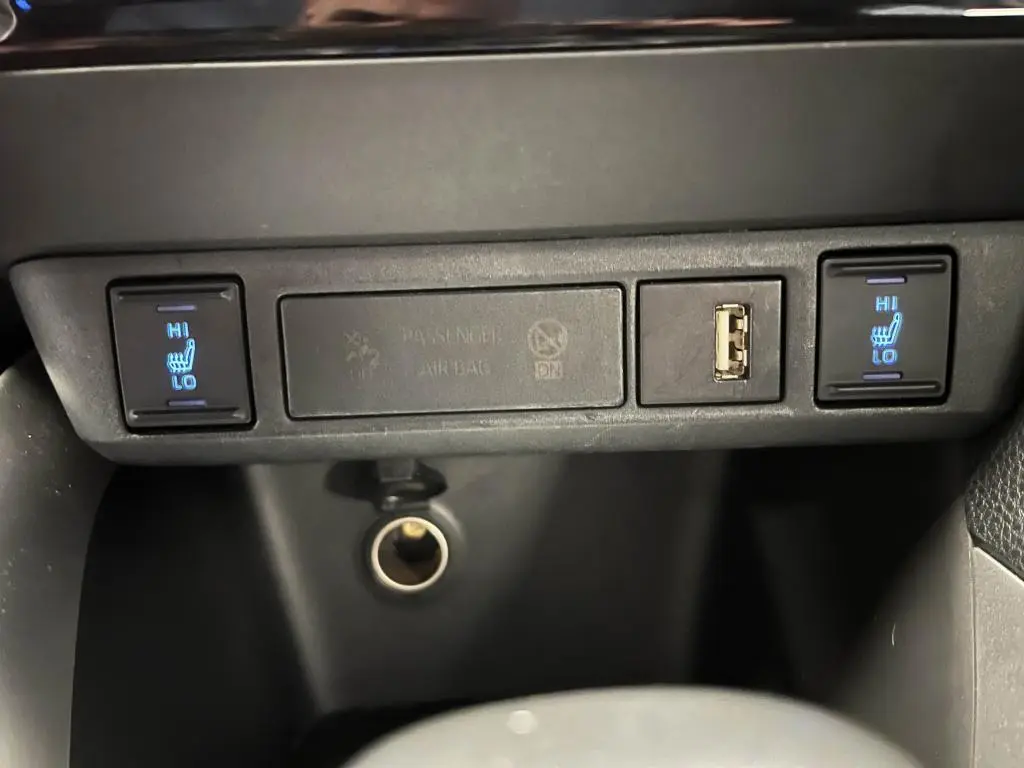 Panneau de commandes intérieur noir de la Mazda2 2023 avec boutons chauffants sièges avant et prise USB visible.