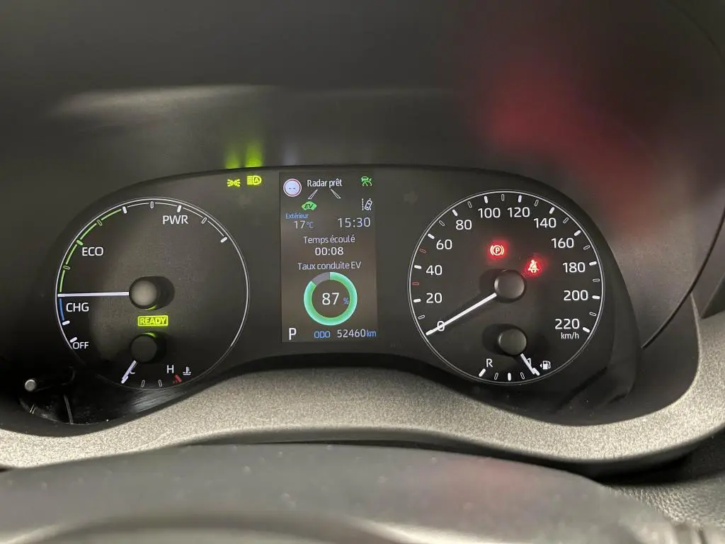 Tableau de bord de Mazda2 hybride 2023 montrant compte-tours, vitesse, et écran central avec indicateur de conduite EV à 87%