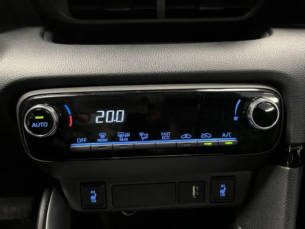 Gros plan sur la commande de climatisation automatique de la Mazda2 noire, affichant 20°C avec boutons éclairés en bleu.