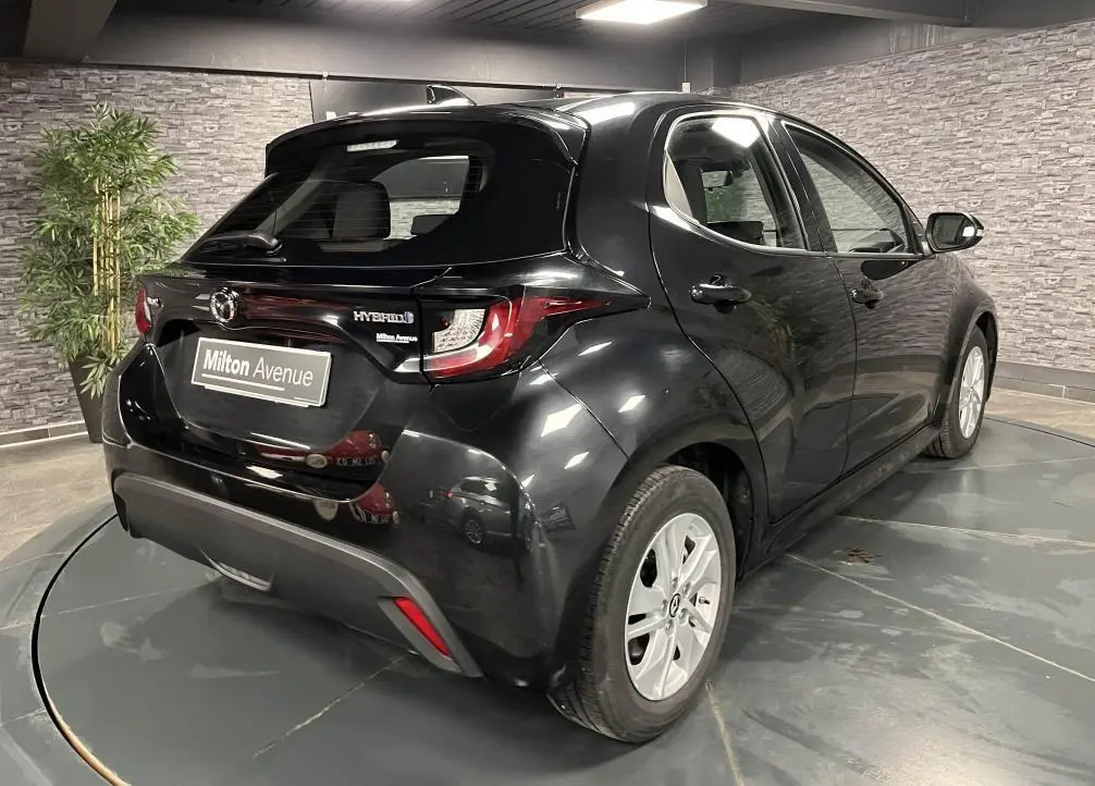 Vue 3/4 arrière droite de la Mazda2 1.5 Hybrid noire avec becquet de toit et jantes alliage 15 pouces silver.