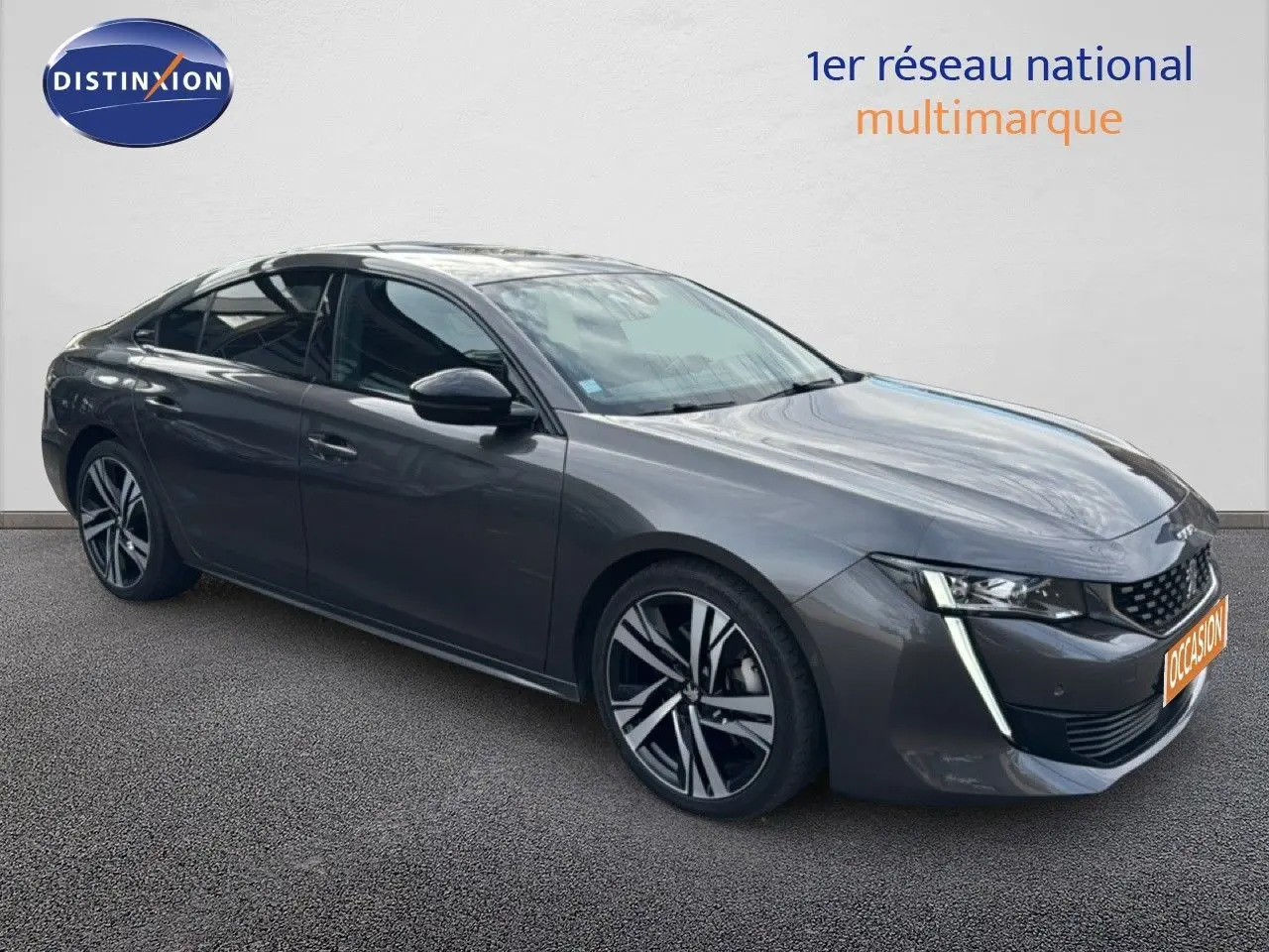 Peugeot 508 gris platinium en 3/4 avant droit, avec jantes alliage bicolores et feux LED distinctifs.