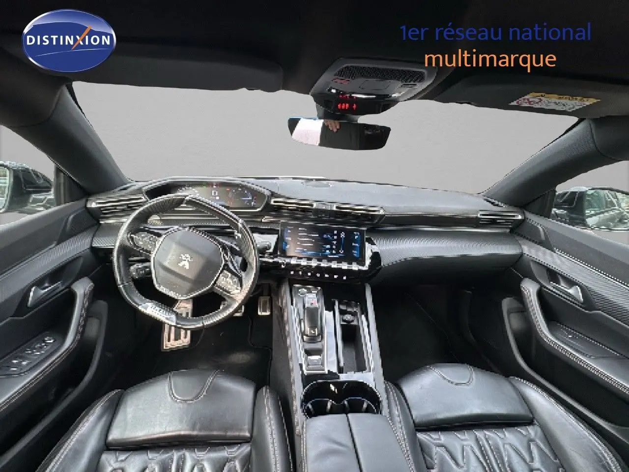 Vue intérieure avant du Peugeot 508 gris platinum 2020, mettant en valeur le tableau de bord et les sièges en cuir noir.