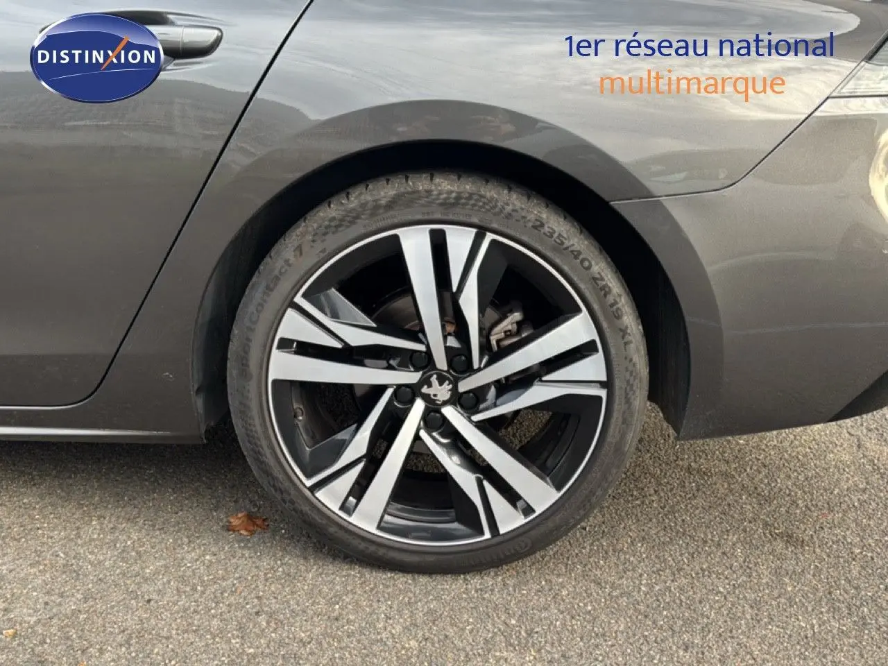 Gros plan sur la roue arrière droite d'une Peugeot 508 gris platinium, avec jante alliage noire et argentée.