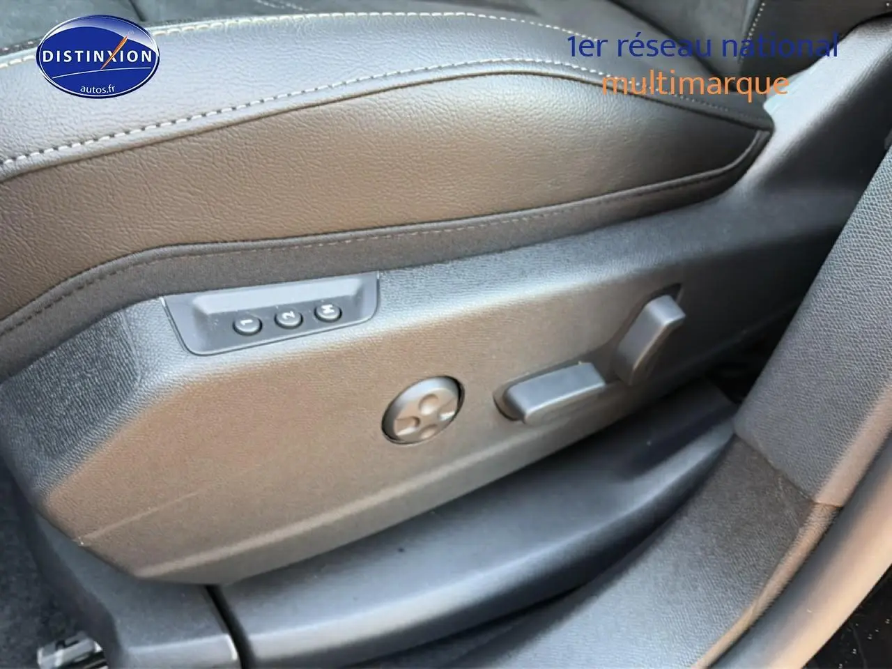 Détail des commandes électriques du siège conducteur en cuir marron du DS7 noir, vue côté gauche.