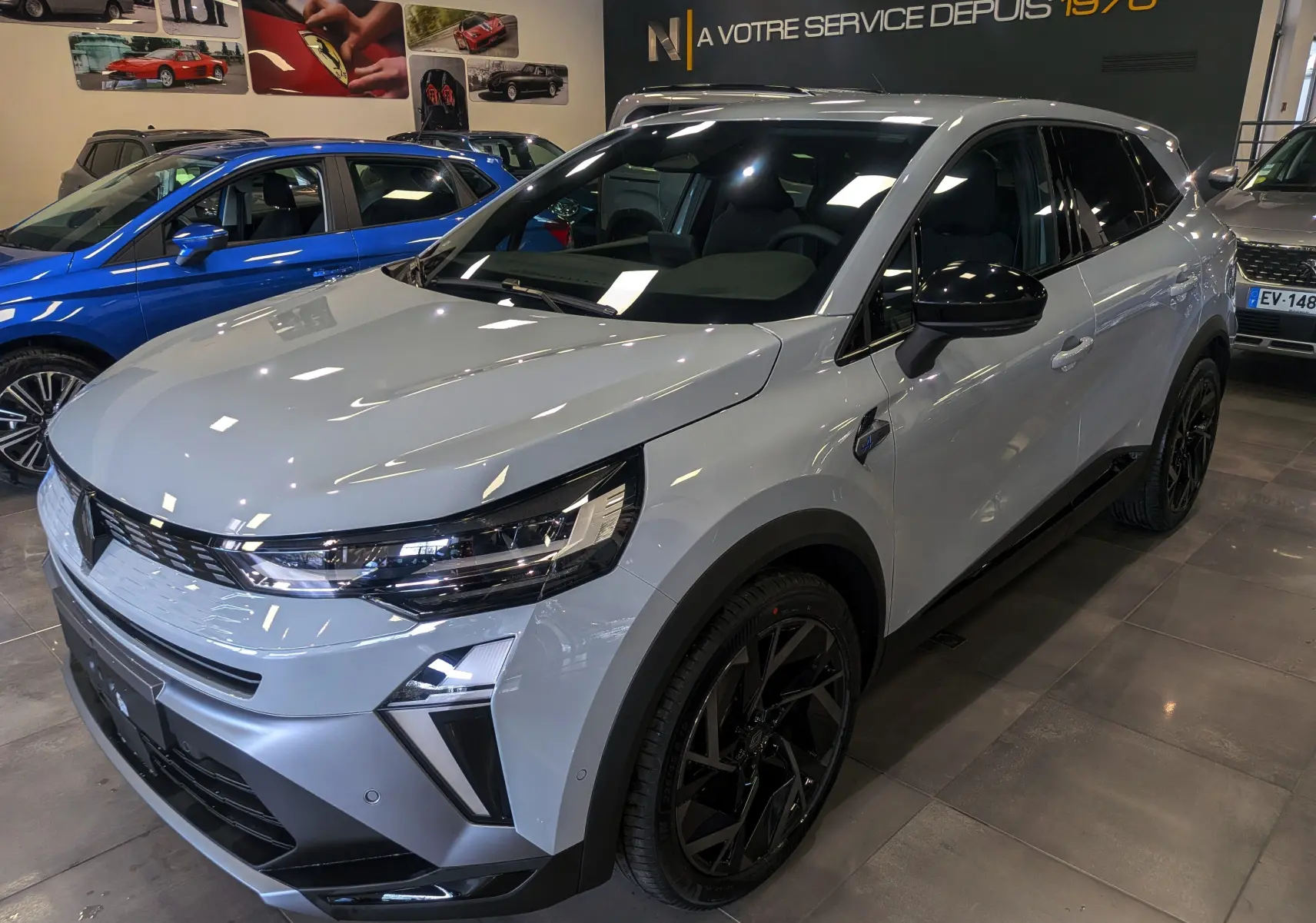 Renault SYMBIOZ E-TECH gris Rafale en 3/4 avant droit, avec jantes noires et détails noirs contrastants.