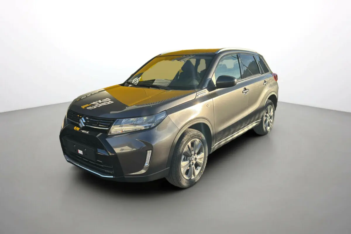 Suzuki Vitara Hybrid 110 Privilege AllGrip 2025 en gris titan, vue 3/4 avant avec jantes alu 17 pouces et feux LED.