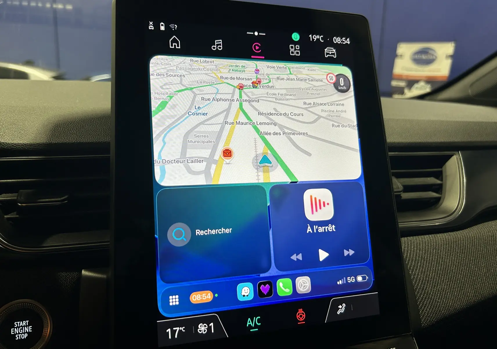 Écran tactile central du tableau de bord du Renault Captur bleu Iron, affichant la navigation GPS et les commandes multimédia.