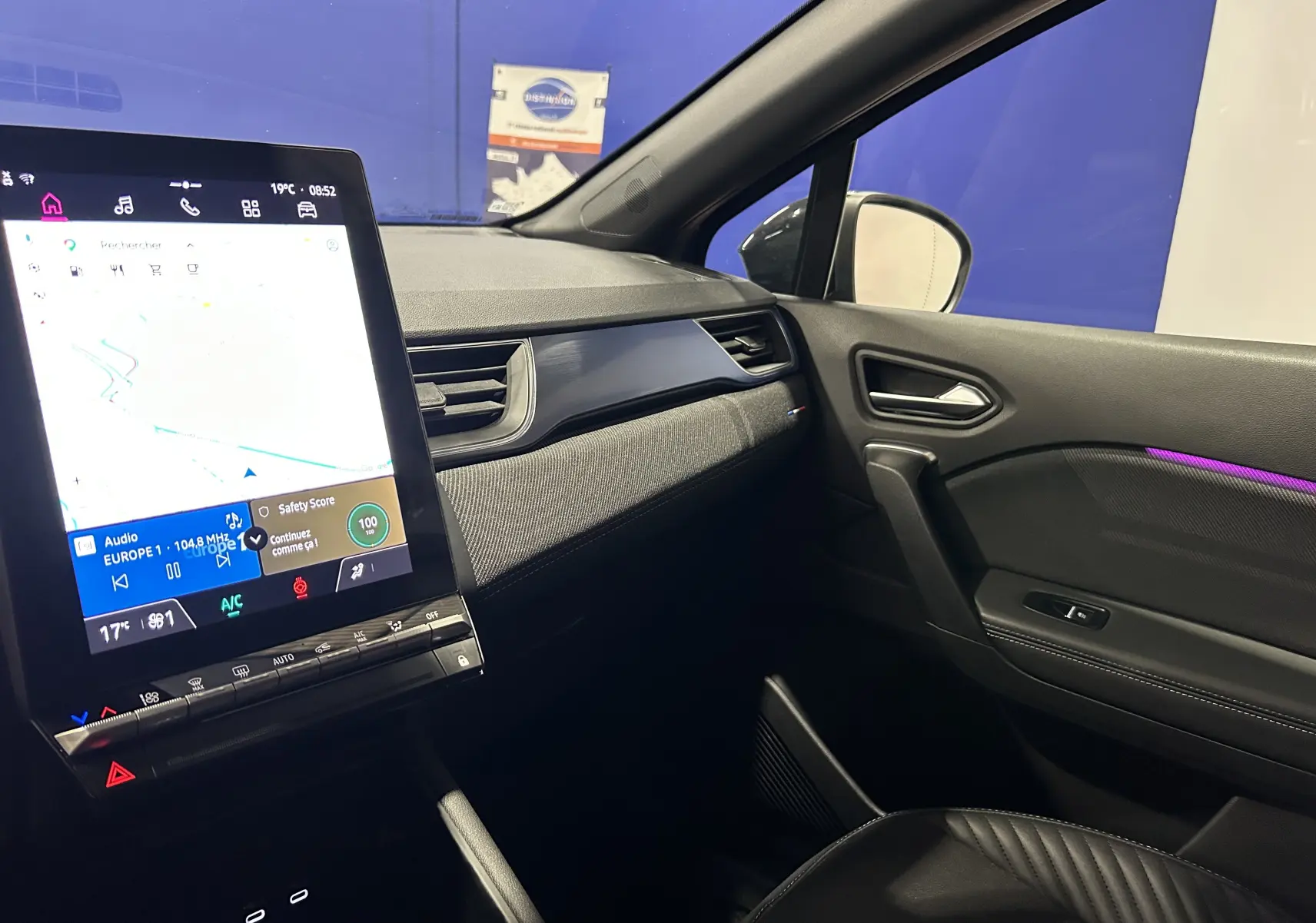 Vue intérieure côté passager du tableau de bord du Renault Captur II Ph.2 avec écran tactile vertical et éclairage d'ambiance violet.