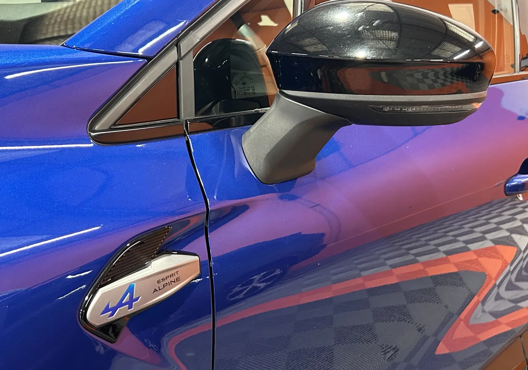Détail du rétroviseur noir et de l'aile avant gauche bleu iron du Renault Captur II Ph.2 E-Tech Esprit Alpine.