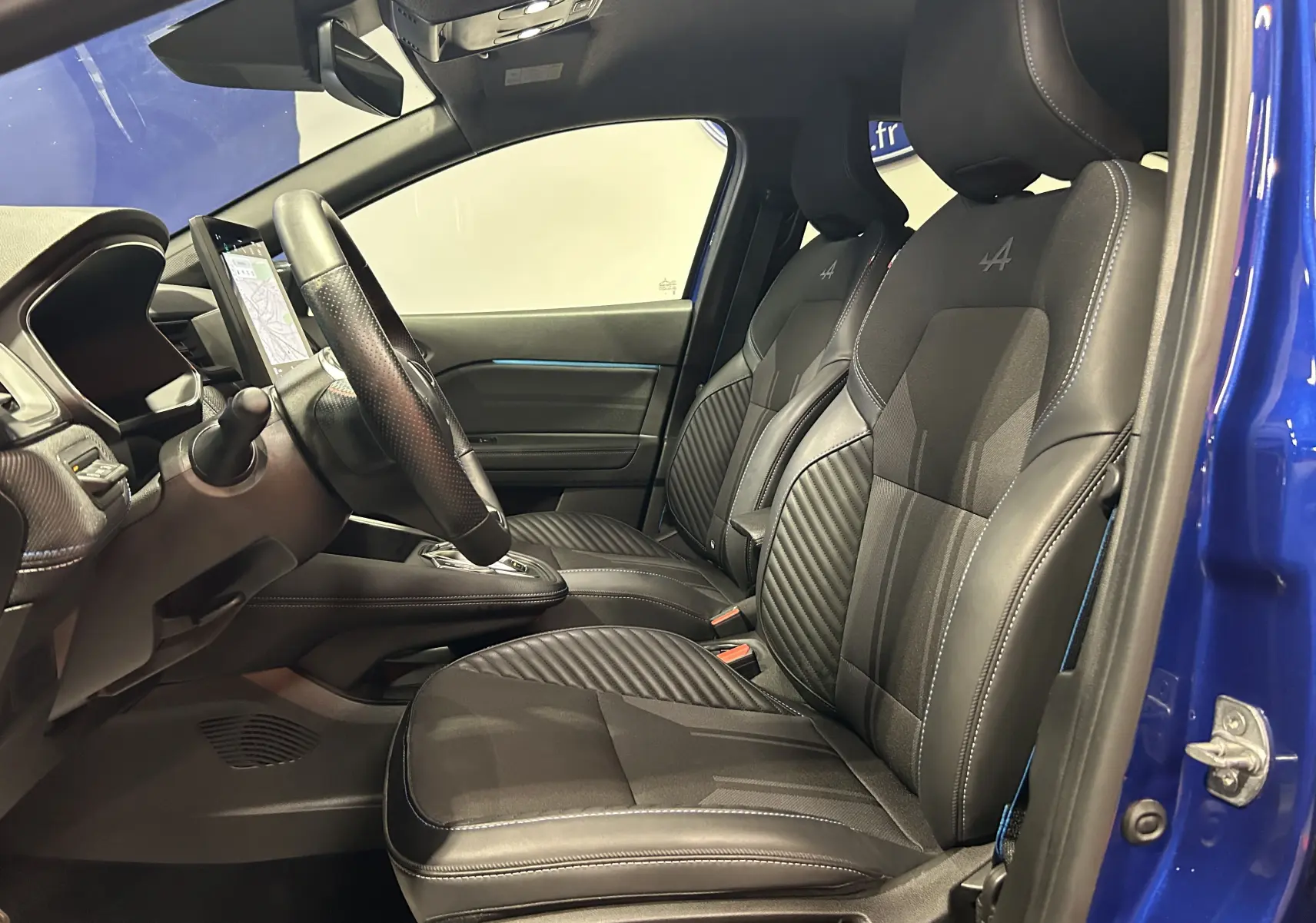 Vue intérieure côté conducteur du Renault Captur II Ph.2 avec volant multifonction, écran tactile vertical et sièges noirs.