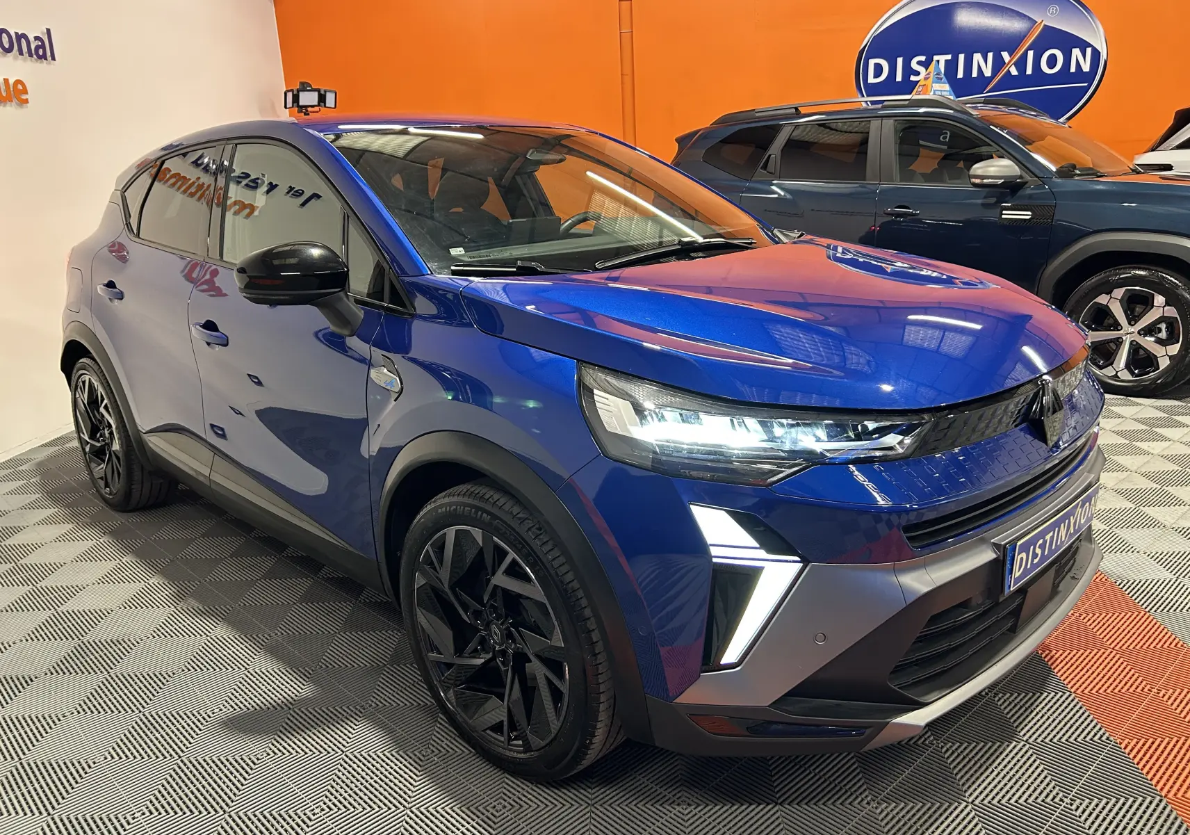 Vue 3/4 avant gauche d’un Renault Captur II Ph.2 E-Tech Full Hybrid 145 en bleu Iron avec jantes noires et feux LED allumés.