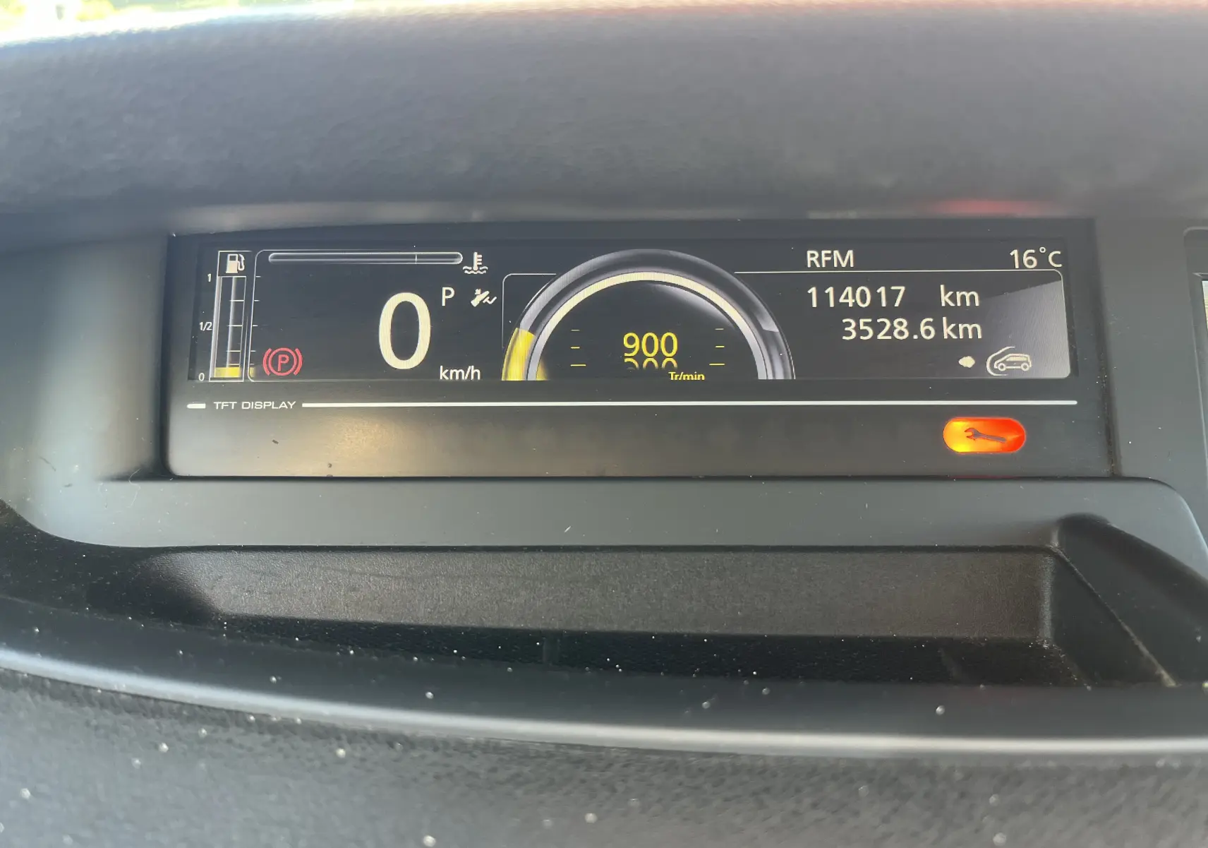 Tableau de bord numérique du Renault Scenic III noir de 2012 affichant 114017 km et température extérieure à 16°C.