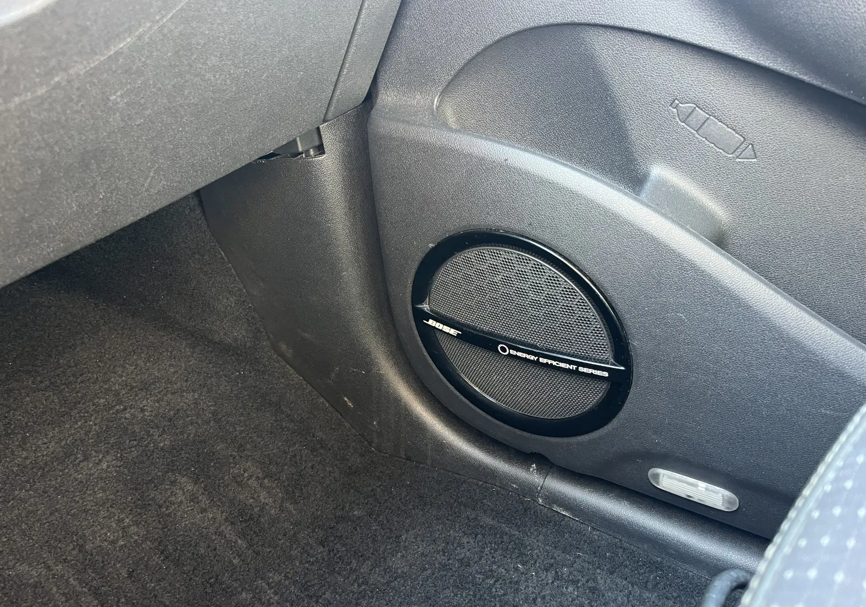 Haut-parleur Bose noir en gros plan sur la partie inférieure côté passager d'un Renault Scenic III 2012.