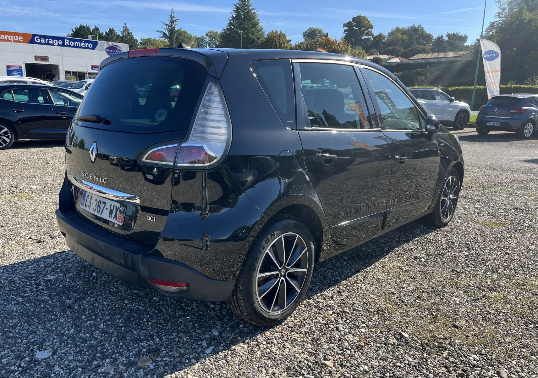 Renault Scénic III noir vu en 3/4 arrière côté gauche, avec jantes alliage et feux arrière caractéristiques.