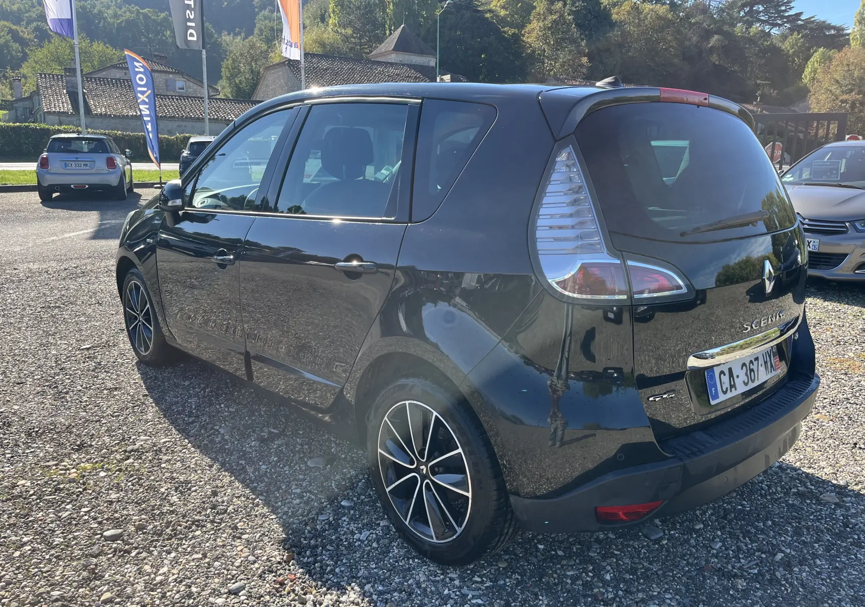 Vue 3/4 arrière droite d'un Renault Scénic III noir de 2012 avec jantes alliage et feux arrière caractéristiques.