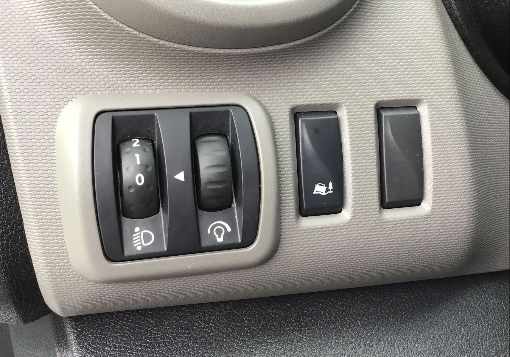 Gros plan sur les commandes d'éclairage et d'assistance au freinage du Renault Trafic Plancher Cabine blanc de 2019.