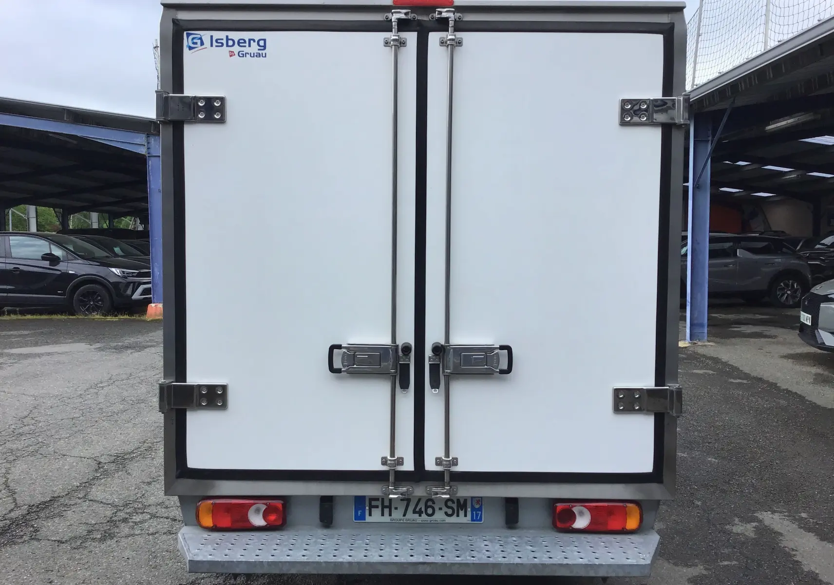 Vue arrière du Renault Trafic Plancher Cabine blanc avec caisse frigorifique Iceberg et portes fermées.