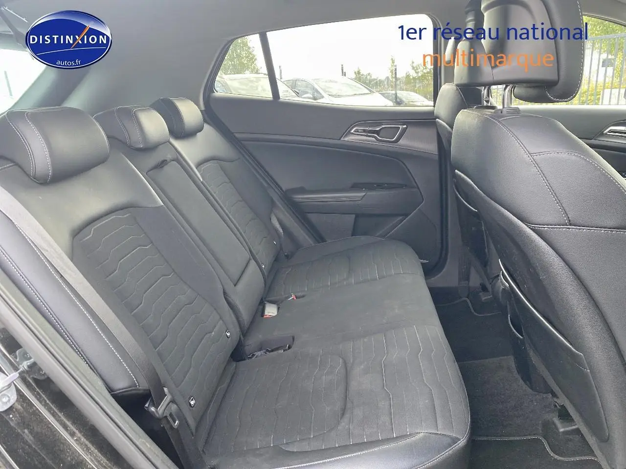 Vue intérieure côté gauche des sièges arrière noirs en tissu et simili du Kia Sportage 2023 avec appuie-têtes réglables.