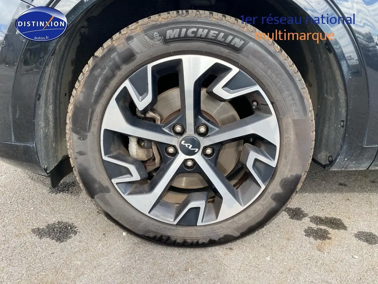 Gros plan sur la roue avant gauche noire du KIA SPORTAGE 2023 avec jante alu et pneu Michelin.