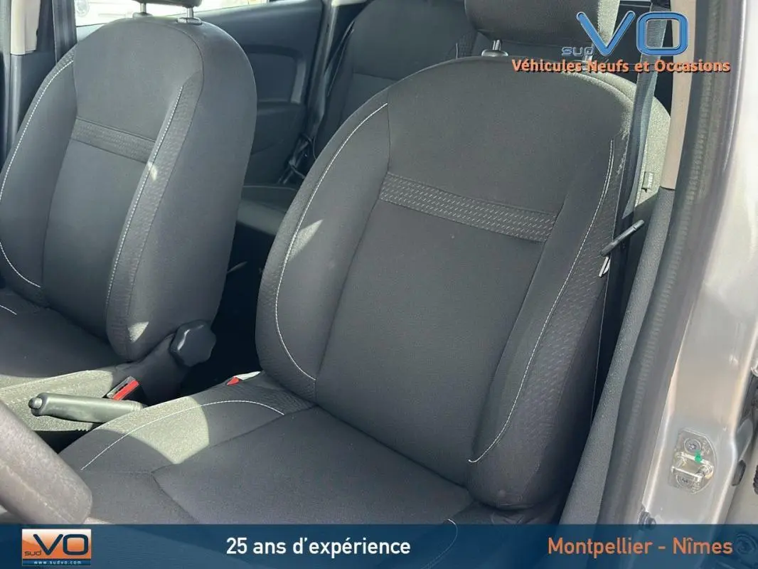 Gros plan sur les sièges avant noirs du Dacia Logan MCV gris clair, avec portière ouverte côté droit.