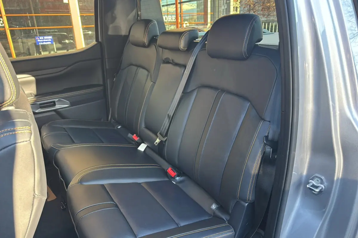 Vue intérieure des sièges arrière en cuir noir avec surpiqûres jaunes du Ford Ranger 2025 gris iconic, porte ouverte côté droit.