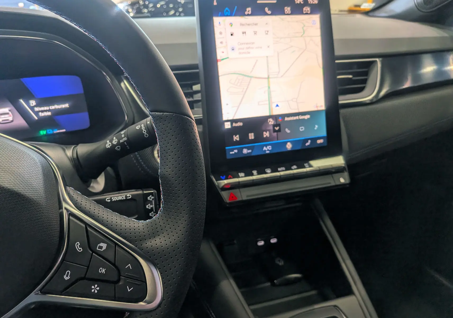 Vue intérieure du tableau de bord et du volant perforé du Renault Symbioz E-TECH, avec écran tactile central affichant la navigation.