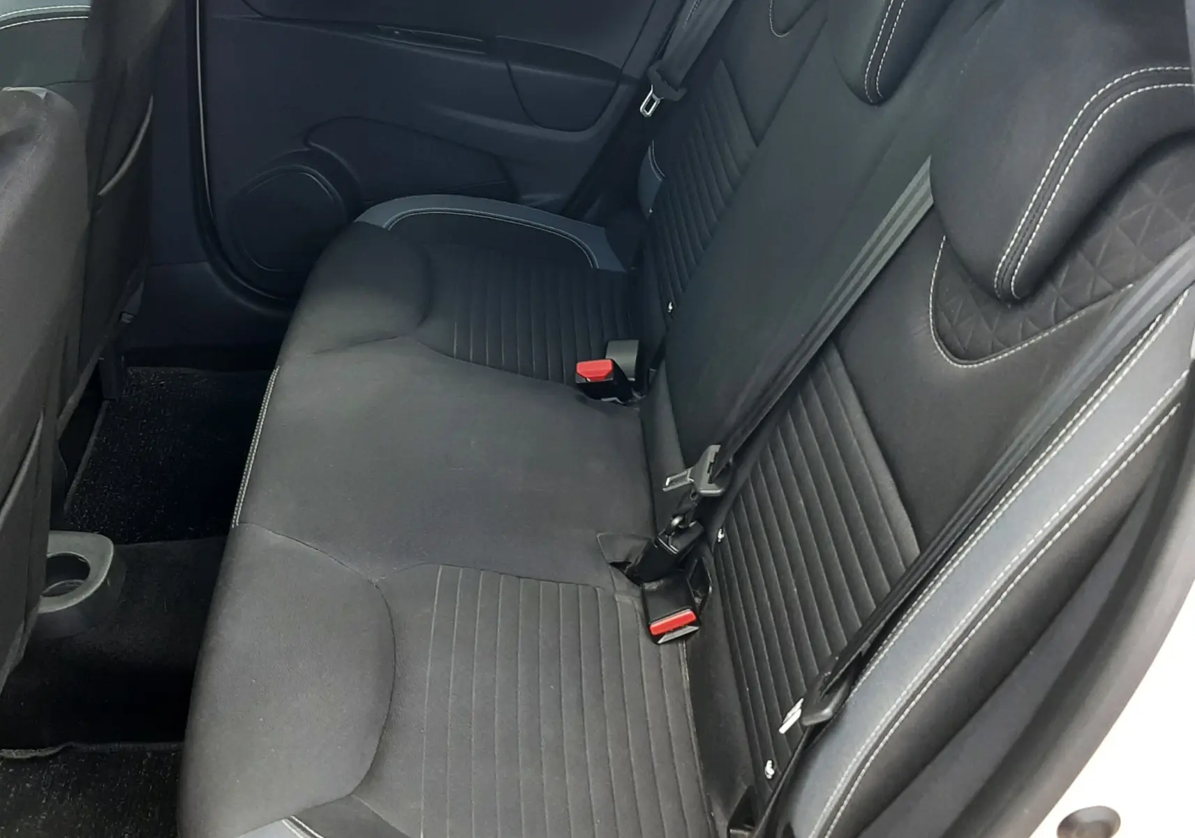 Vue intérieure côté droit des sièges arrière noirs en tissu avec surpiqûres blanches de la Renault Clio IV Estate TCe 90ch Intens.