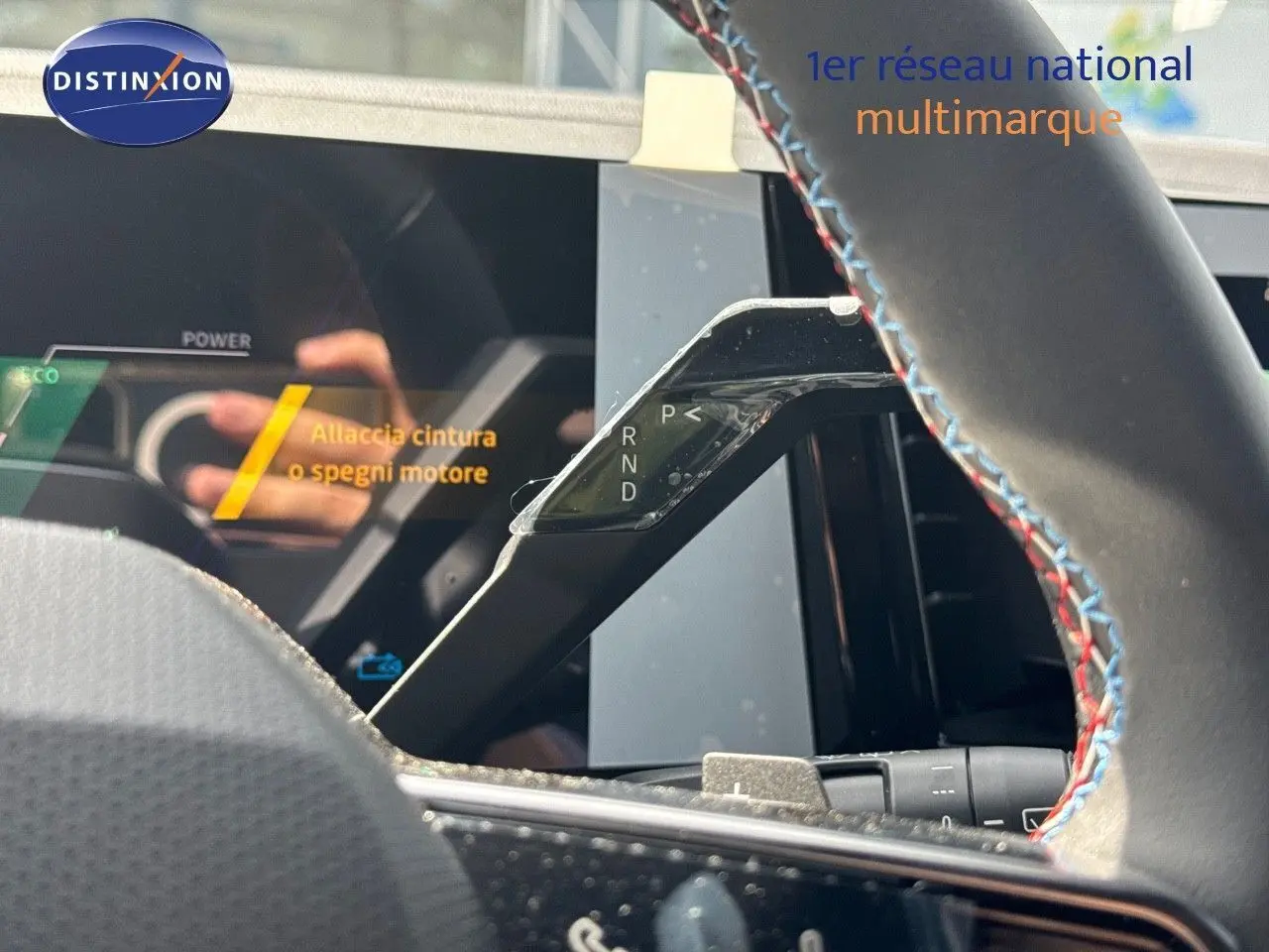 Le levier de boîte automatique noir avec marquages P, R, N, D visible derrière le volant au cuir noir surpiqué bleu et rouge du Renault Austral 2024.