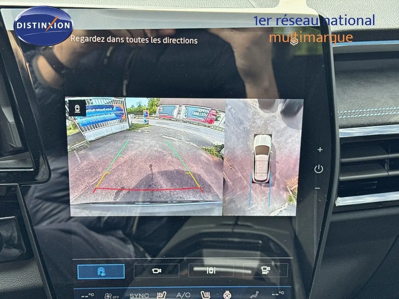 Écran de caméra de recul du Renault Austral gris schiste avec toit noir, vue arrière et top-down du stationnement.