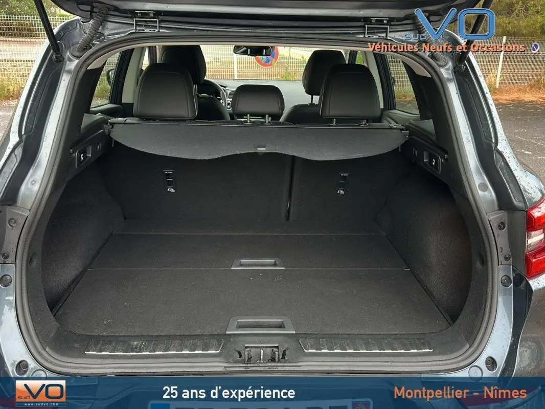Coffre ouvert d'un Renault Kadjar gris 2019, vue arrière montrant l'espace de chargement et les sièges arrière rabattables.