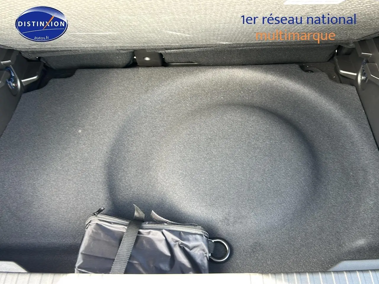 Coffre ouvert du Renault Captur noir Étoile, vue plongeante sur la zone de rangement avec trousse noire.