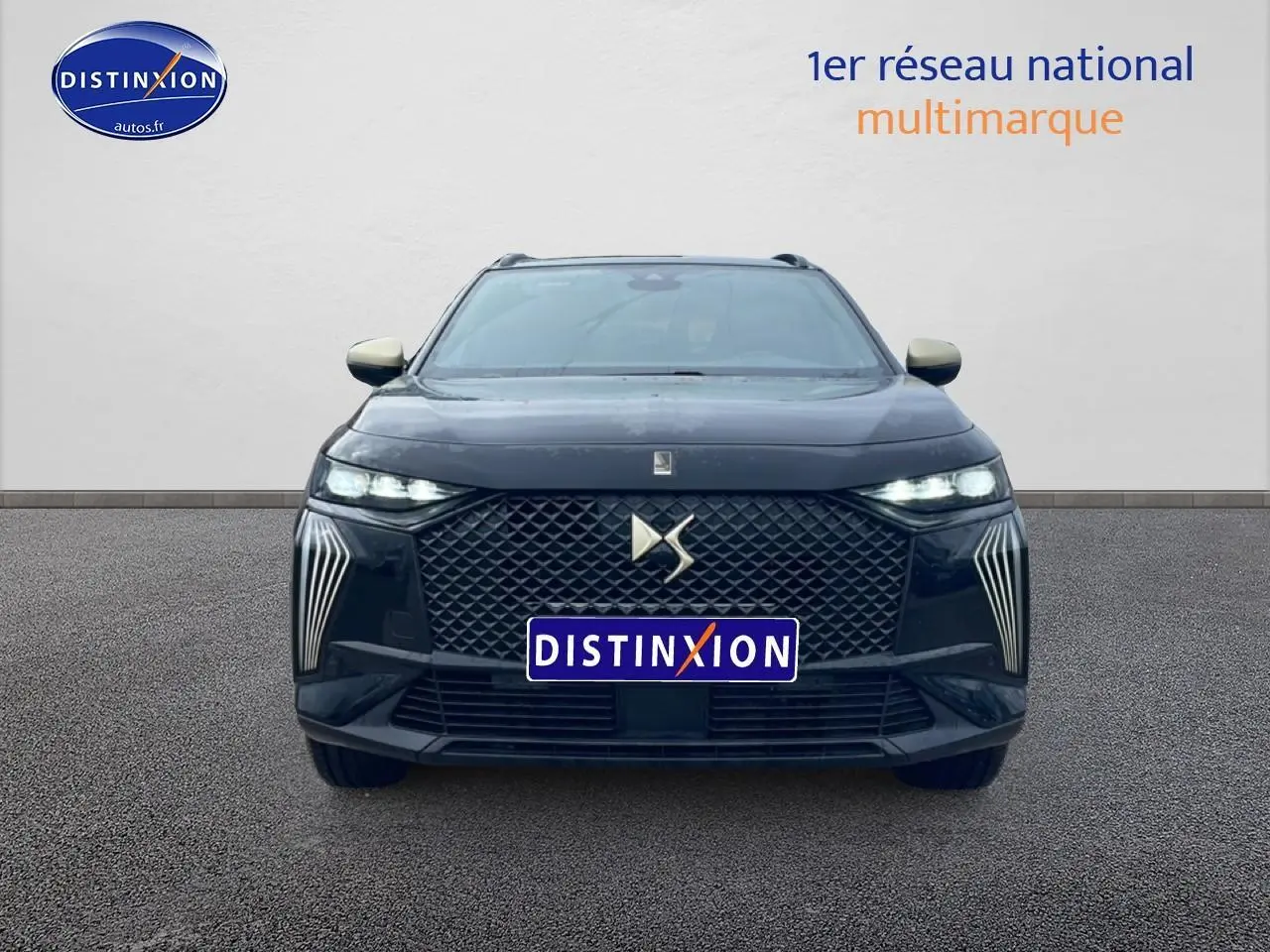 Vue frontale d'un DS7 noir 2026 avec calandre distinctive et phares LED allumés sur fond neutre.