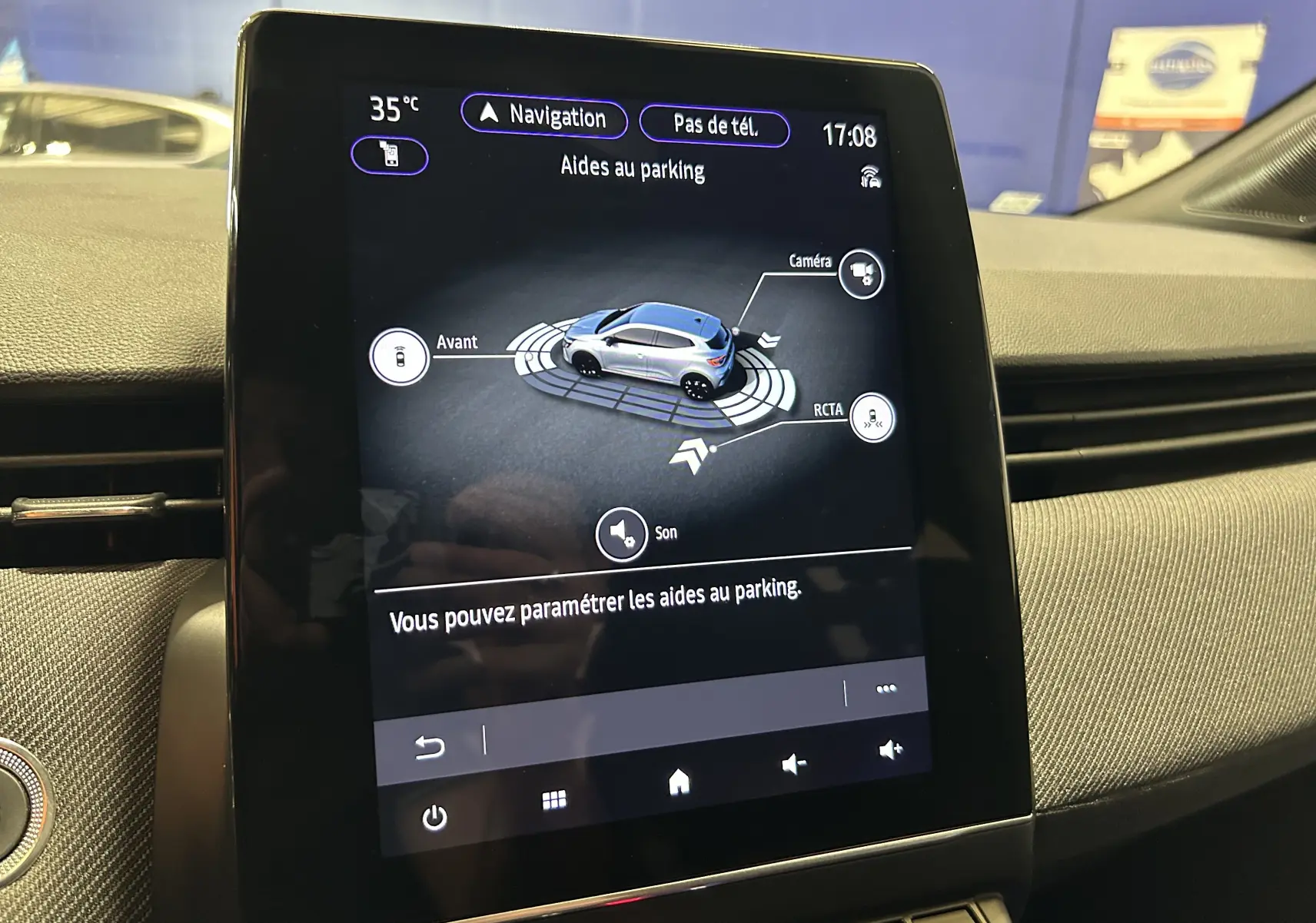 Écran tactile intérieur de Renault Clio V gris schiste montrant l'interface d'aides au parking avec vue 3D du véhicule.