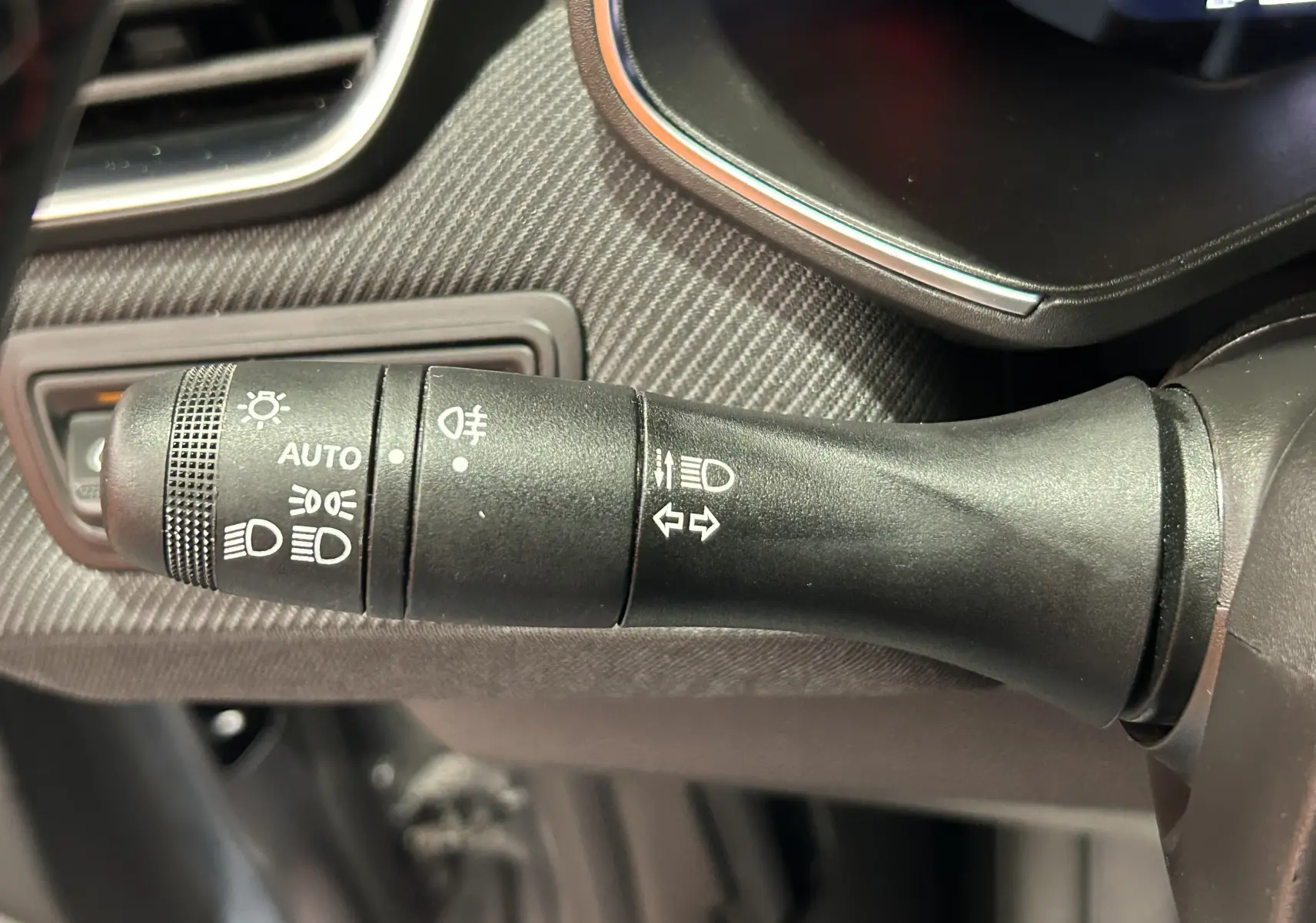 Gros plan sur la commande des phares et clignotants à gauche du volant dans une Renault Clio V TCe 90 Esprit Alpine.