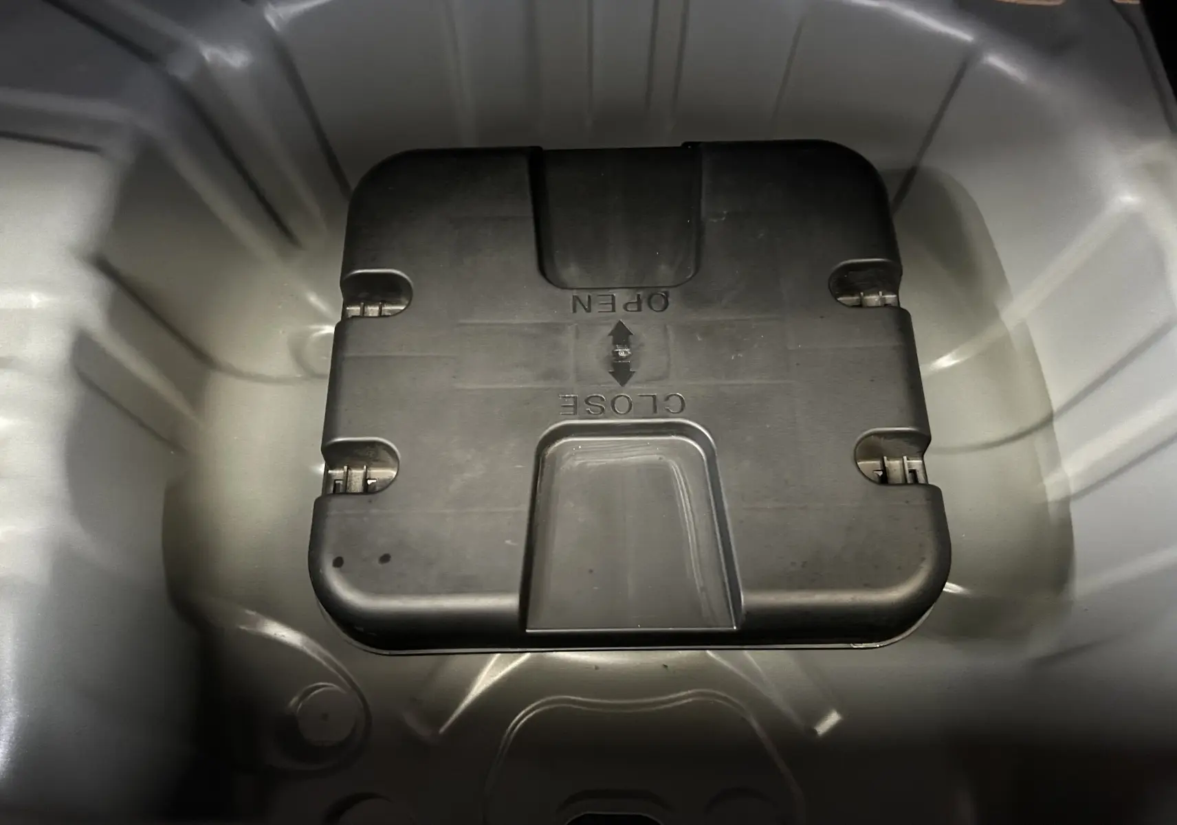 Gros plan sur le coffre à outils sous le plancher de coffre de la Renault Clio V TCe 90 Esprit Alpine gris schiste.