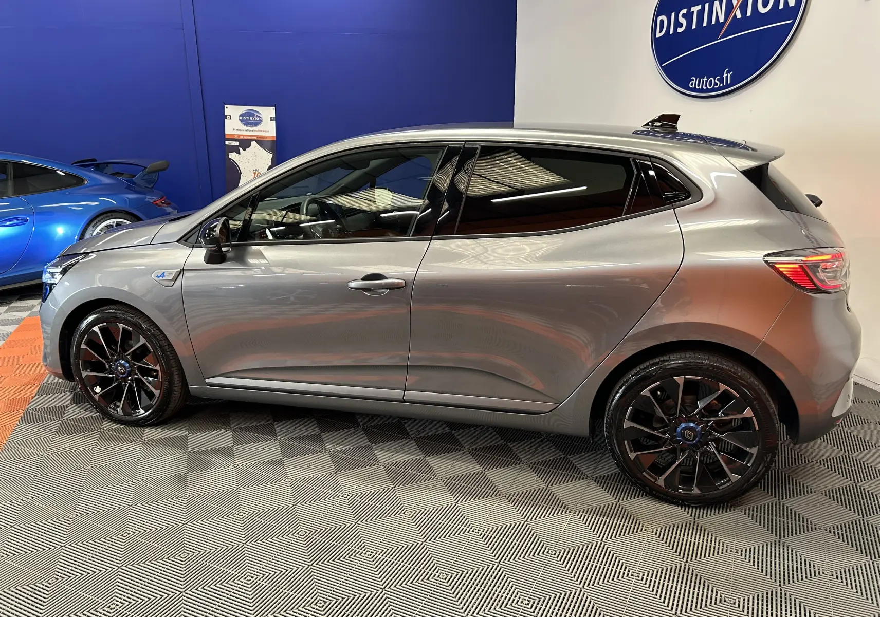 Profil côté gauche de la Renault Clio V TCe 90 Esprit Alpine gris schiste avec jantes noires en concession.